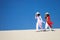 Vietnamese women wearing traditional suit walking in the desert