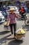 Vietnamise saleswoman in traditional clothes sales fruits on street