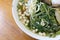 Vietnamse noodle soup, served with fresh herbs at the buddhist eatery, radish, morning glory, shiitake and tofu in white bowl on W