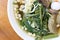 Vietnamse noodle soup, served with fresh herbs at the buddhist eatery, radish, morning glory, shiitake and tofu in white bowl on W