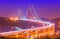 View of The 25th April Bridge Ponte 25 de Abril with car light trails in haze. Popular landmark of Lisbon, Portugal