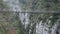 View from above of a bridge crossing between mountains and a walking couple