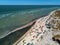 View from above of bright colorful kites lying parked on beach on windy day at kitesurfing spot. A lot of parachutes for