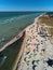 View from above of bright colorful kites lying parked on beach on windy day at kitesurfing spot. A lot of parachutes for