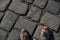 View from above on brown boots on cobblestone pavement background