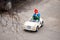 view from above, the child rides in children`s car, drives a car, a little boy in a red hat looks around