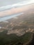 A view from above of the city with buildings, houses from the porthole, aircraft windows on the wing with engines, turbines and wh