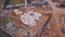 View from above of the construction site in progress, workers building new house or workshop and construction materials