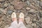 A view from above on the feet of a woman standing on a rocky surface