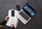 View from above. Female hands make notes in notebook. Near on table smartphone, laptop with inscription on monitor- cloud library