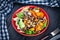 View from above on fresh, homemade vegan bowl. vegetarian salad of carrots, mushrooms, lettuce in orange bowl on dark wooden