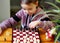 View from above. The girl learns to play table chess.Cultural leisure of children. Board games are an alternative to computer