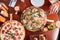 View from above of girl taking slice of pepperoni pizza