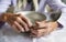 View from above.The hands of an old grandmother of 90 years are holding an empty aluminum bowl and spoon, poverty and poverty, the