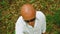 View from above. Portrait of a bald man in sunglasses standing in the forest and looking at the camera. Close up shot.