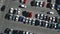 A view from above to the process of car parking. Heavy traffic in the parking lot. Searching for spaces in the busy car