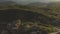 A view from above on a valley strewn with huge stones at the foot of a high cliff. A sunset panorama of the Caucasus