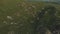 A view from above on a valley strewn with huge stones at the foot of a high cliff. A sunset panorama of the Caucasus