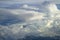 View of abstract soft free form wind blow white cloud with shades of blue sky background from above flying plane window