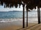 view of Acapulco beach from a palapa with palm roof and wooden supports on a sunny day