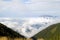 A view of the Achishkho mountain in the Caucasus from the pass Bzerpinsky cornice, towering above the clouds