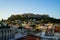 View of the Acropolis, Erechtheion, from Monasteraki Square through old town buildings and Hadrian`s Library ruins