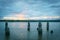 View across bay and old wharf posts at dusk on cloudy evening