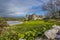 A view across a bramble topped wall of the Carew River and the ruins of the old castle in Pembrokeshire, UK