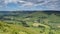 View across Edale valley and Kinder Scout plateau with white clouds and blue sky, Peak District, UK