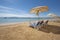 View across an empty tropical beach with sun loungers to the sea