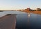 A view across the lake in southport at sunset with a jetty in front of buildings on the waterfront