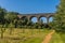 A view across a park towards a section of the Chappel Viaduct near Colchester, UK