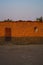 View of adobe house bathed in orange light in Malanje village