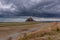 View from afar on Le Mont-Saint-Michel island under storm clouds