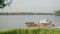 A view from afar of a small river pier with one yacht on a sunny calm summer day