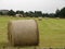 View of agriculture field after harvest with hay rolls, rural landscape