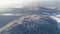 View from the air on road serpentines between beautiful trees covered with snow.