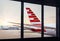 View of airplane fuselage tail through window at airport