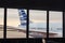 View of airplane fuselage tail through window at airport