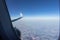 View from the airplane porthole. Blue sky, bright rainbow with the shadow of the plane.