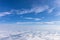 View from the airplane to the sky above the Alps mountains. Blue