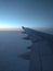 View from airplane window to beautiful sunrise or sunset. Wing of plane and clouds in the sky