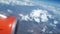 View from the airplane window to the blue sky and white clouds, an orange turbine on the wing of the plane, a view of