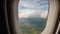 View through an airplane window on the tropical island, ocean, sea, sky and clouds. Aerial view sea, clouds and sky as