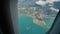 View through an airplane window on the tropical island, ocean, sea, sky and clouds. Aerial view sea, clouds and sky as