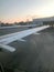 View of the airport, hangars from the porthole, the windows of the aircraft on the wing with engines, turbines after landing