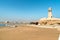 View of Al Ayjah Lighthouse with fish boat on the beach in Sur, Sultanate of Oman