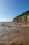A view along the beach at Pett Level in East Sussex, with a blue sky overhead