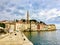 A view along the boardwalk facing the old town of Rovinj, Croatia. Old colourful buildings and the clock tower are the skyline