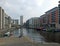 View along the clarence dock development in leeds with waterfront buildings reflected in the water boats and lock railings